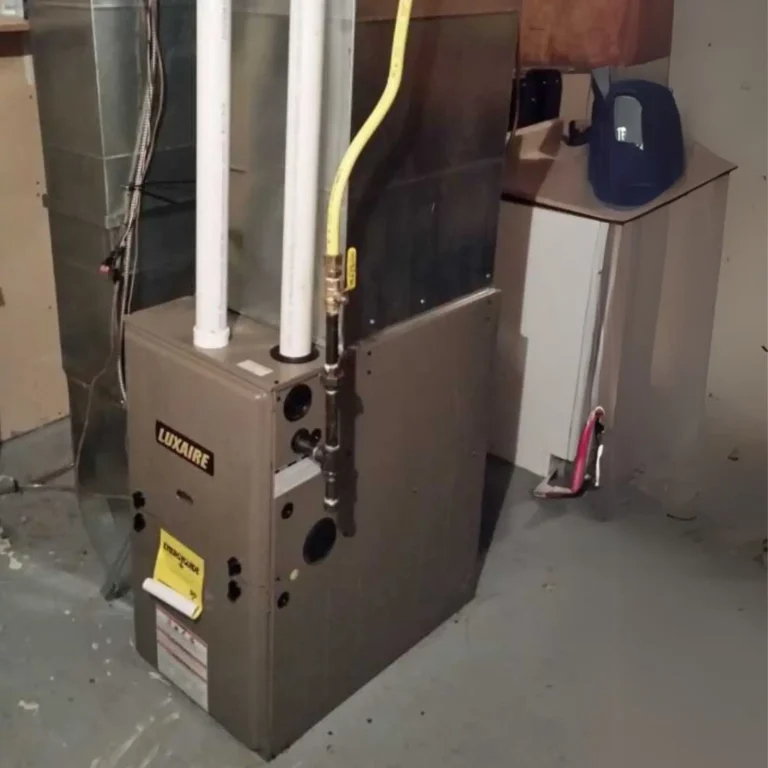 Luxaire gas furnace installation with PVC venting and gas lines in a basement setting.